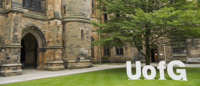 Students during graduation with the UofG sign